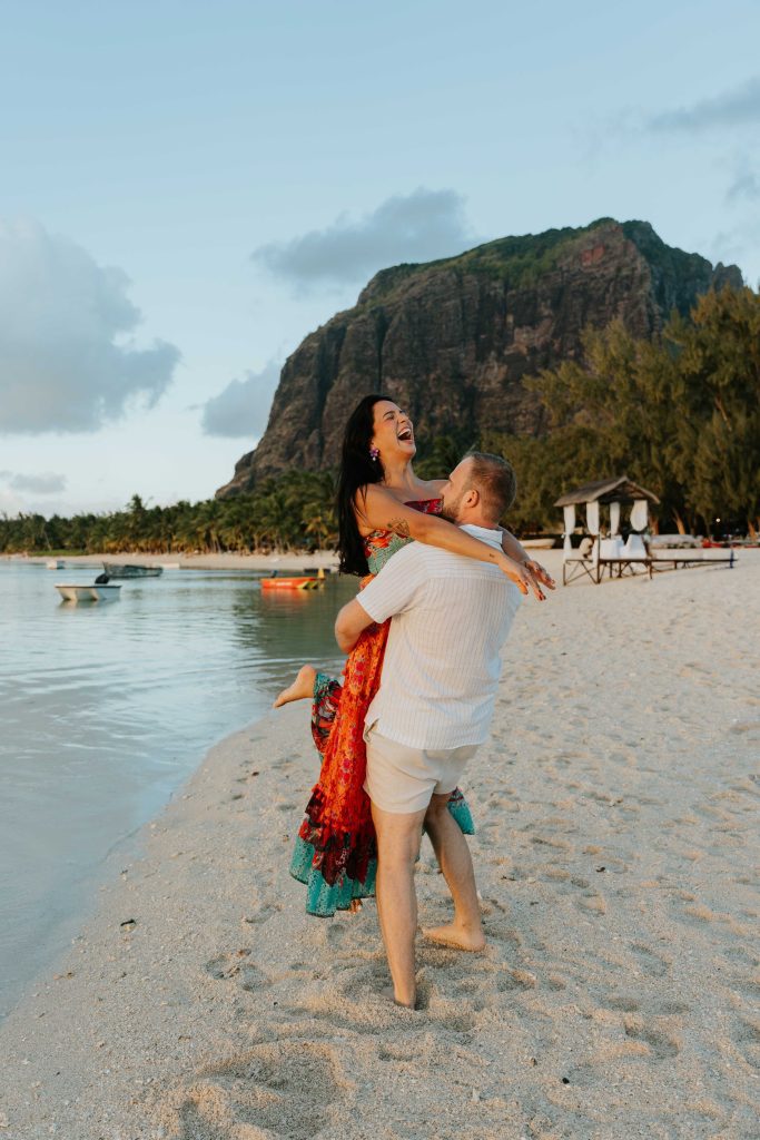 Couple walking on Le Morne Beach sunset